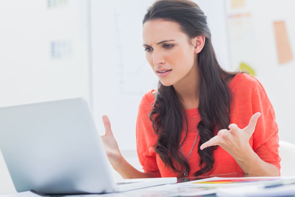 Annoyed designer gesturing in front of her laptop in her office-1