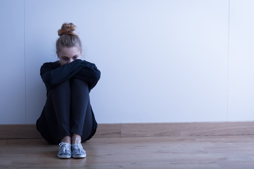 Sad woman with depression sitting on the floor-1